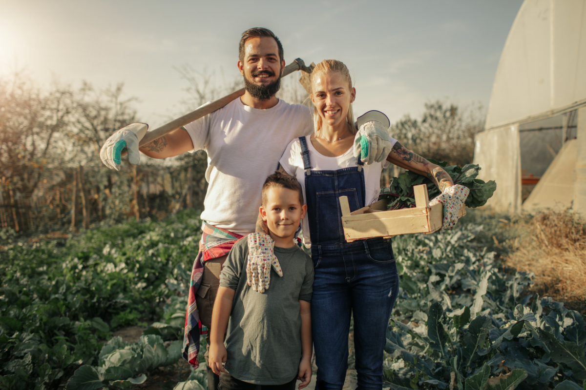 Szczęśliwa rodzina rolników BIO z koszem warzyw